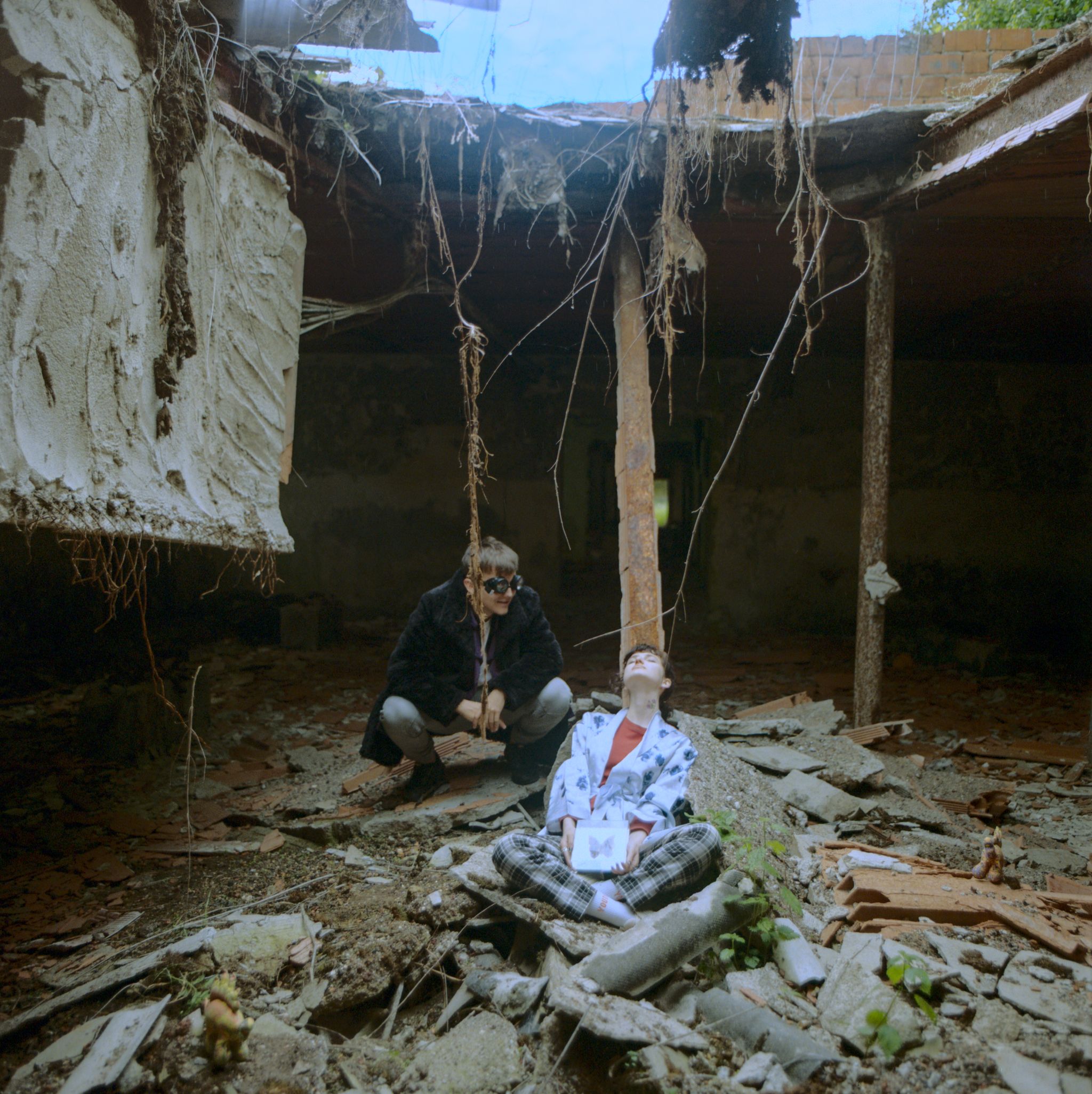 A boy and a girl under a fallen rooftop