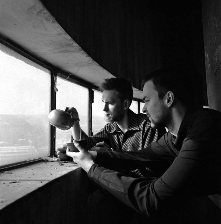 Two men drinking tea in a former train water tower
