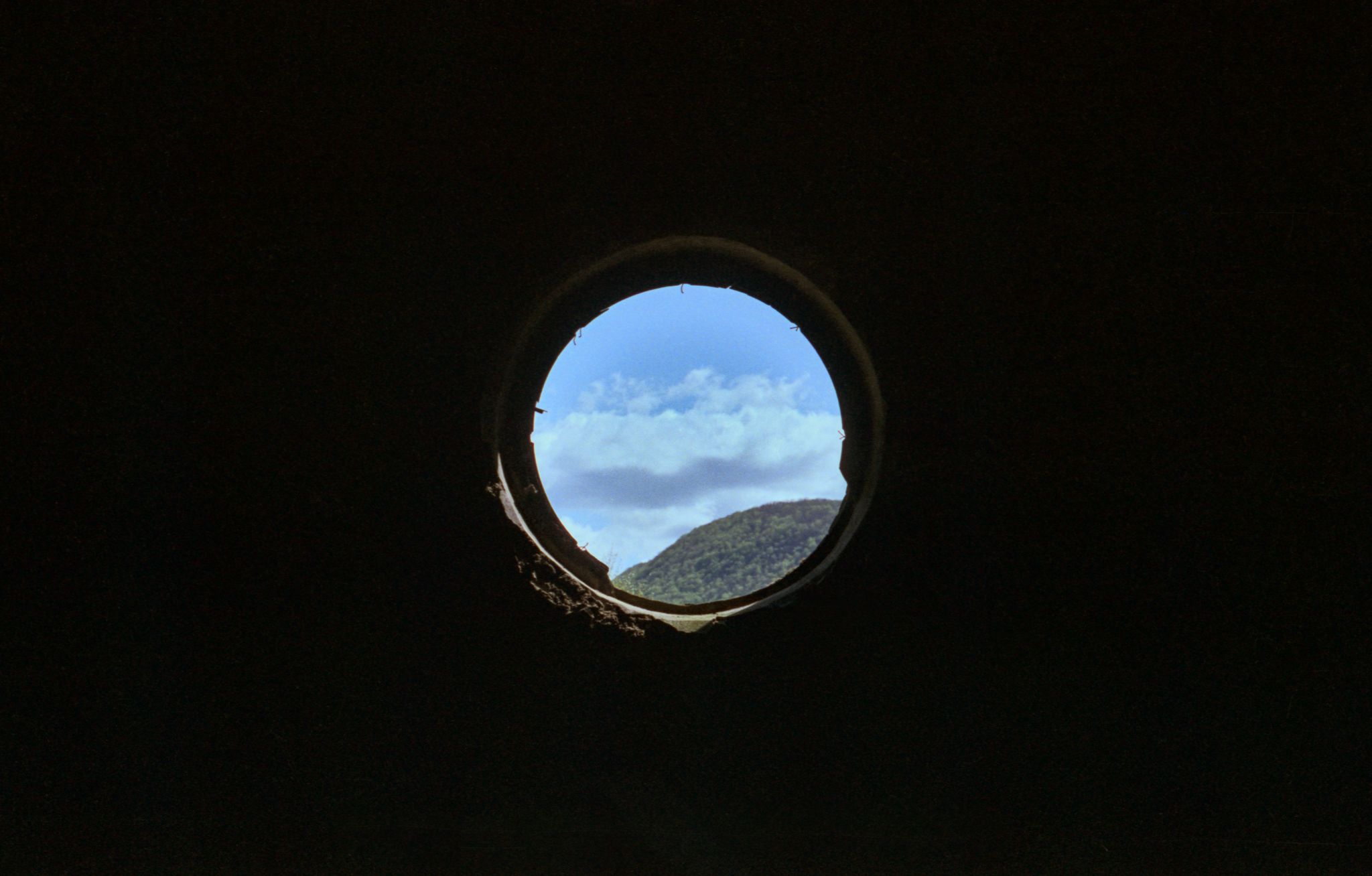 A circular window in a ruined train station