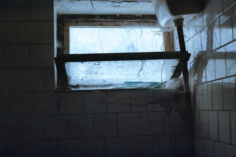 A window on a toilet in a ruined collective farm