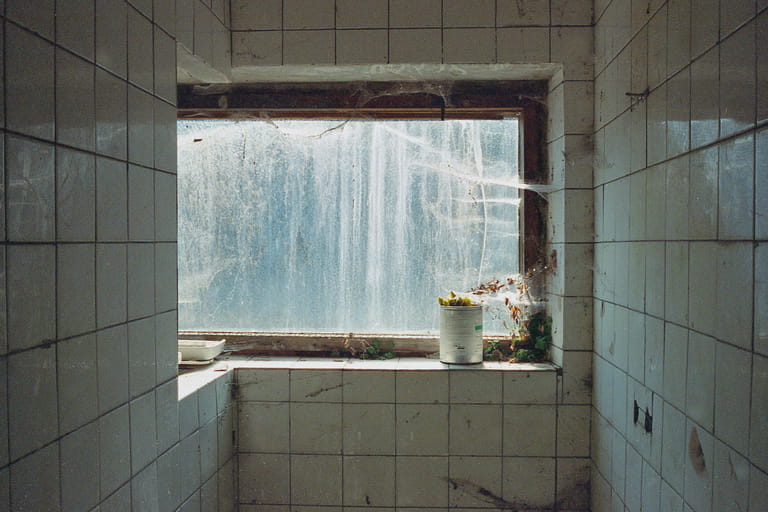 A window in a ruined collective farm with a can